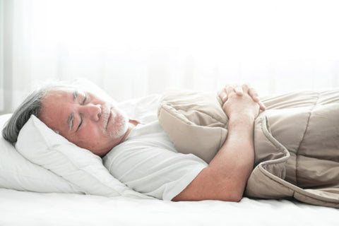 the image shows a man sleeping in bed on a comfy mattress