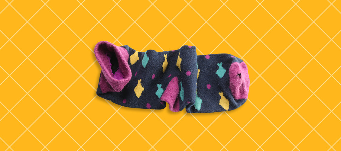 Crumpled worn-out fish socks with a small hole in the toe