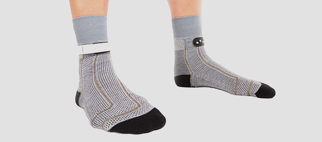 Man wearing gray crew-length smart socks with a sensors on the ankle - 10 Unexpected Socks