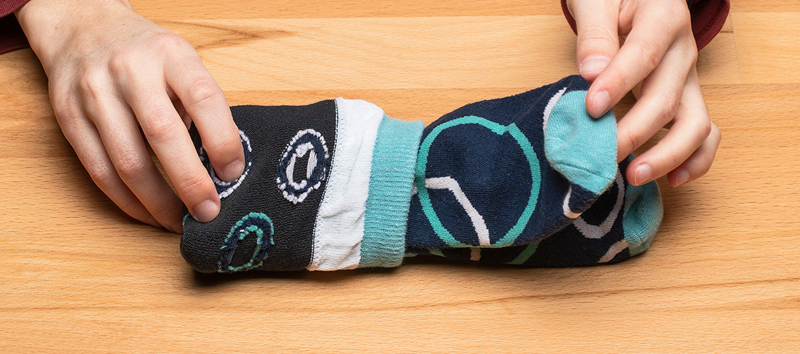 Hands folding bubble socks using the flip and tuck method