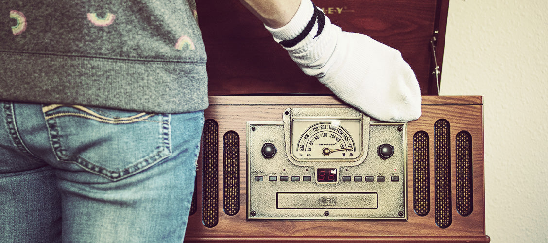 Woman wearing old white sock on hand dusting antique record player - 15 Uses for Old Socks