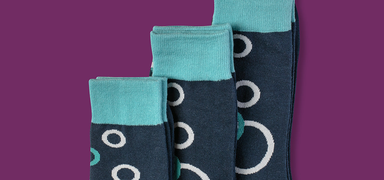 Stacked blue bubble socks with teal cuffs in different sizes - Goldie Socks