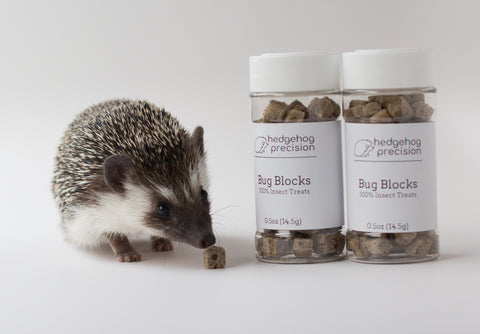 Hedgehog next to two bottles of Bug Blocks treats