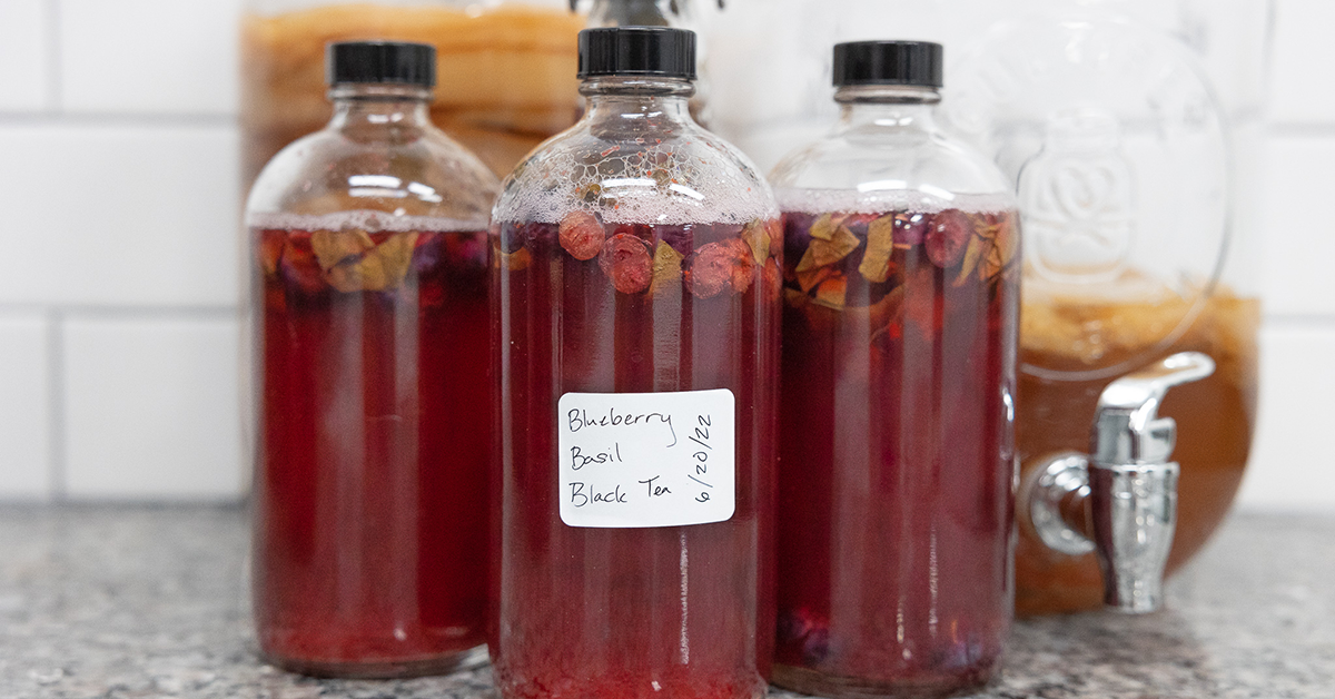 staged photo of blueberry kombucha with basil