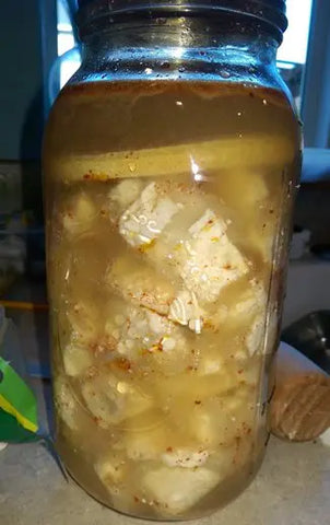 Cubes Tofu in a Quart Jar Covered with ingredients used in Lacto- Fermented Sufu, pepper flakes