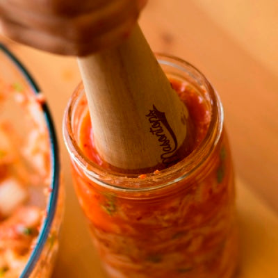 Kimchi in a Glass Container Pounded with Wooden Tool