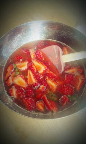 Sliced Strawberries with Melted Sugar in a Stainless Bowl stir with Rubber Spatula