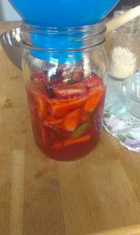 Straining the Strawberry mixture in a Glass Container