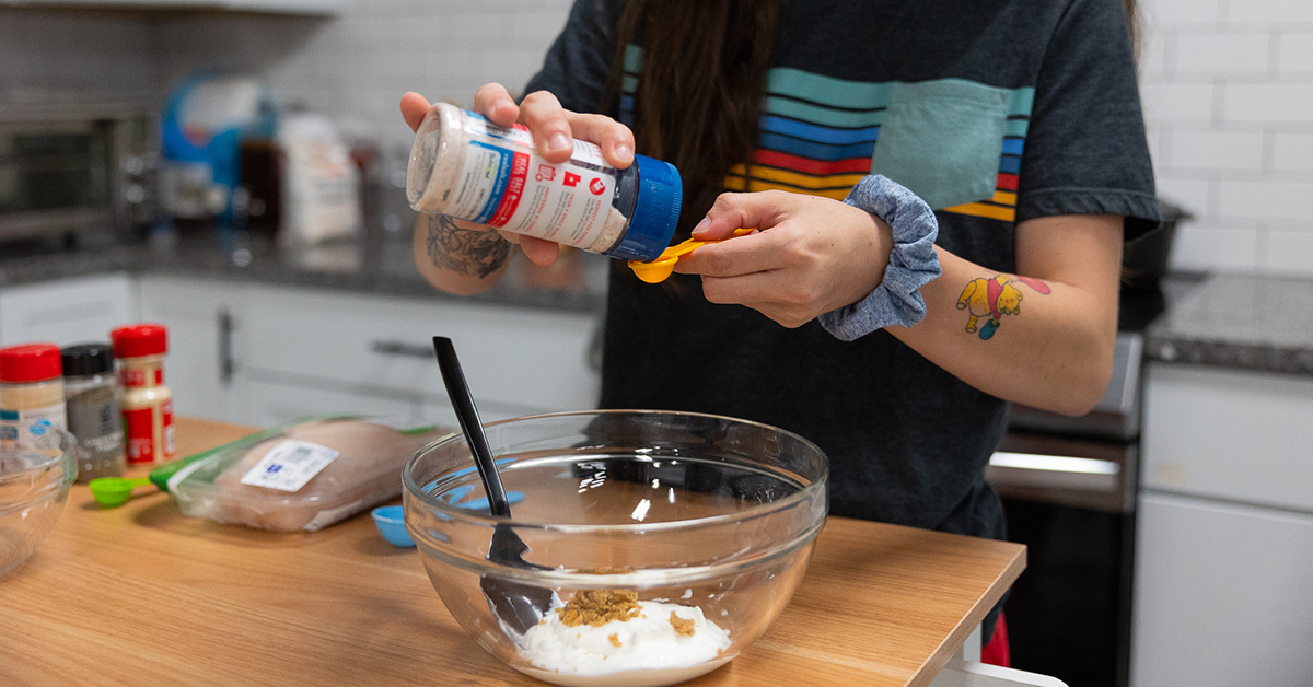 adding ingredients to spicy yogurt chicken marinade 