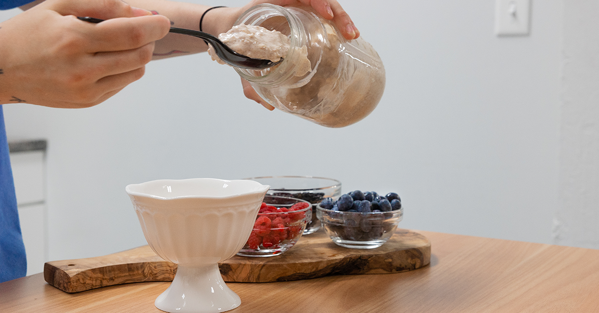 someone putting overnight oats into a bowl