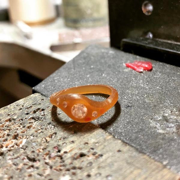 Finalizing the shape of the ring in wax and placing the stones