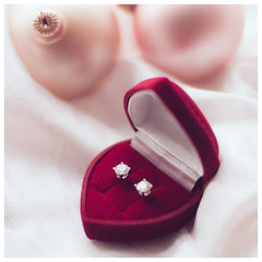 diamond studs in a red velvet jewellery box