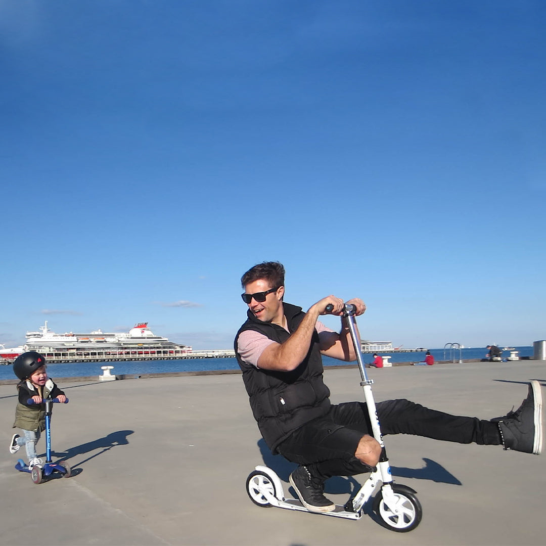 Dad and son on their Micro Scooters along the waterfront
