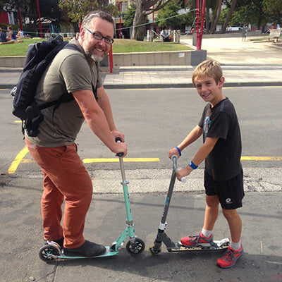 Micro Dad and son scooting together