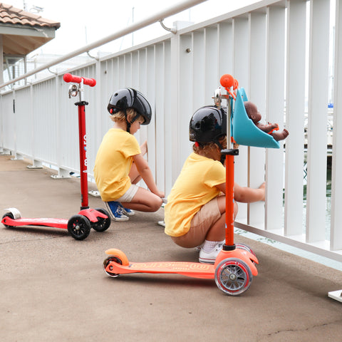 Preschoolers playing on their 3 wheel scooters