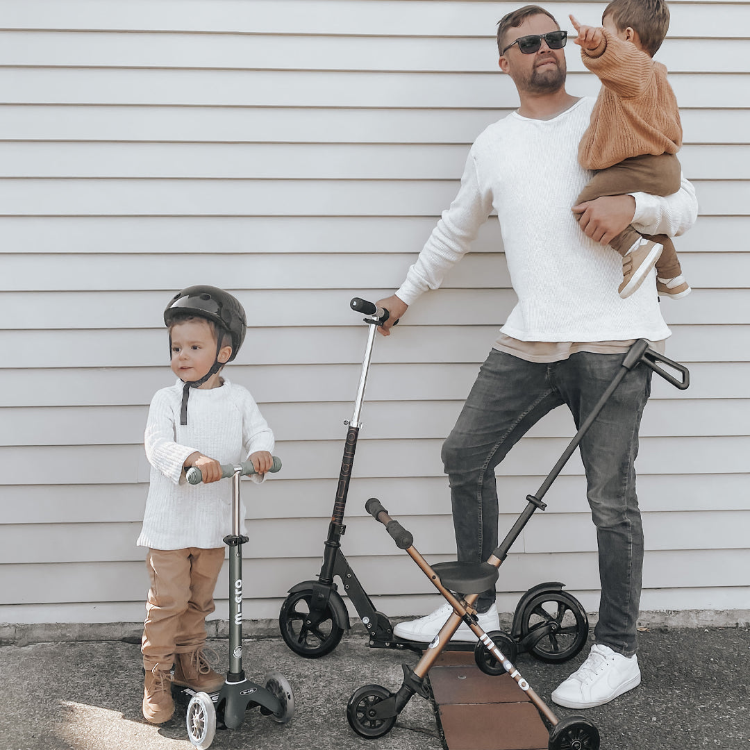 Dad having fun with his kids on scooters