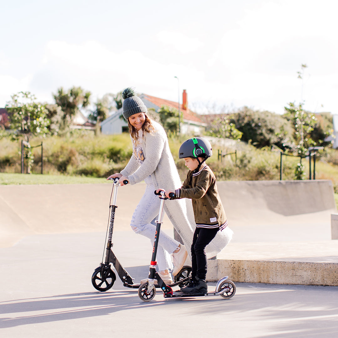 mother and son at the skatepark on their adult 2 wheel scooters