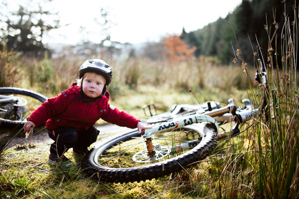 mountain bike kid standing next to dads bike