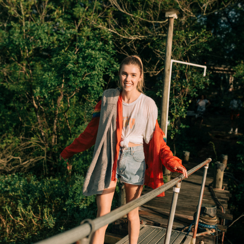 A girl walking in nature on a bridge over a river