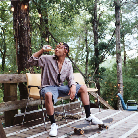 A man drinking a beer on a park bench