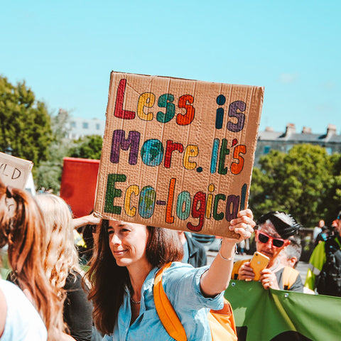 woman-protesting-with-a-less-is-more-anti-fast-fashion-sign