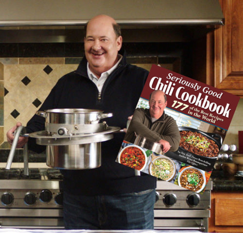 Brian Baumgartner holding cooking pots and a copy of the Seriously Good Chili Cookbook