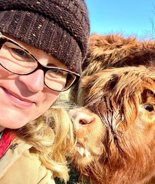 brown micro cow nibbling lady's hair