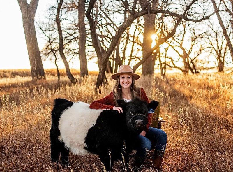 woman posing with mini Belted Galloway