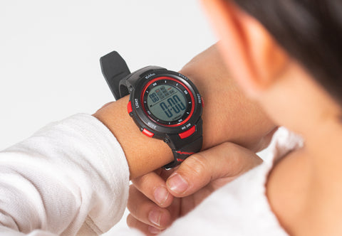 Close up photo of a kid using a Kiddus digital watch.