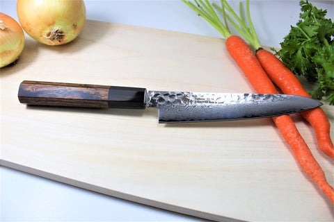 Japanese petty knife on cutting board with carrots and onions