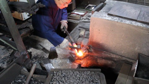 Knife maker works to create a blade