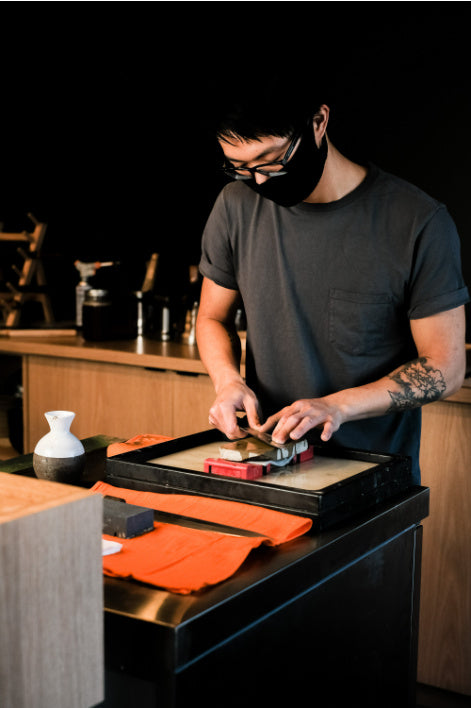 Man sharpening Japanese knives with whetstone