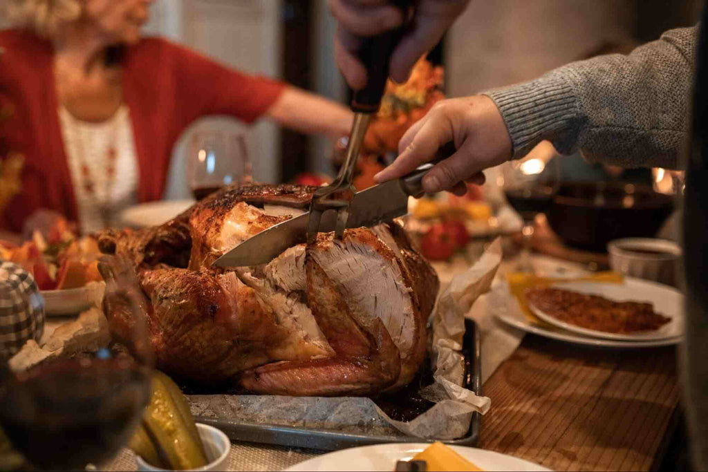 Person Slicing the Turkey Breast on a Dinner Table