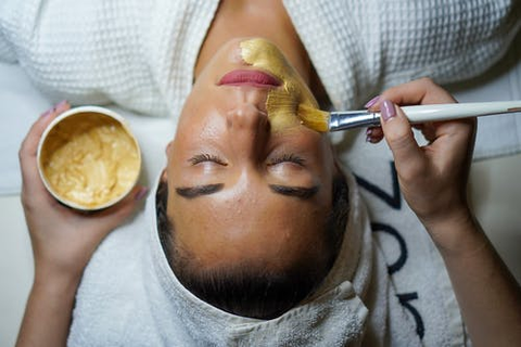 a woman applying a face mask