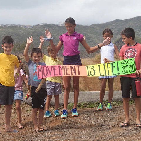 Children holding up "movement is life" banner