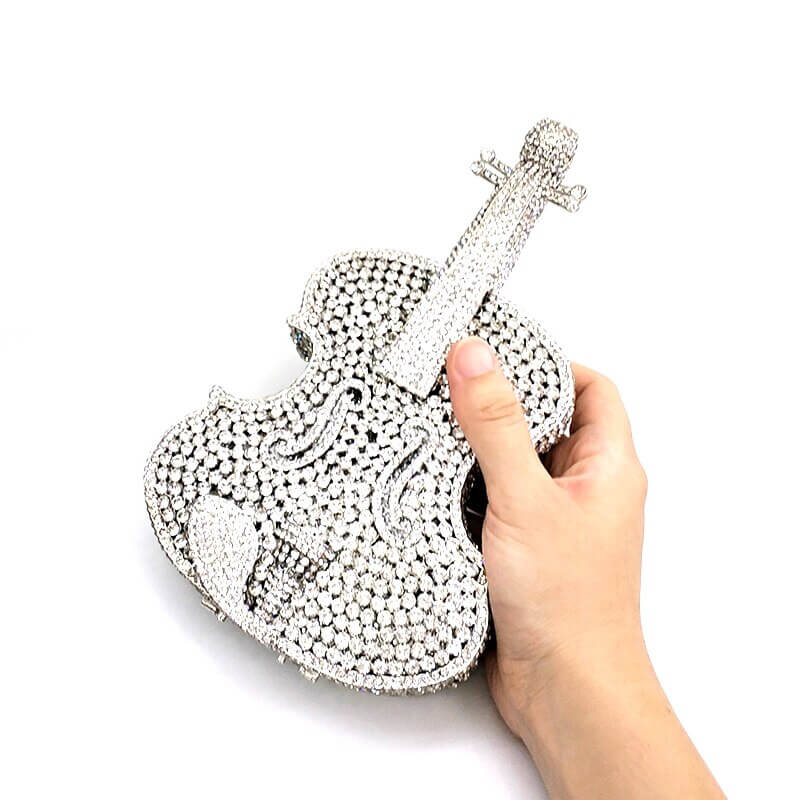 hold a silver violin purse in hand