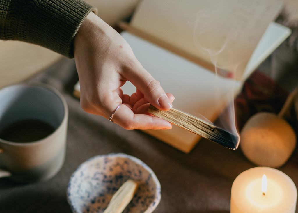 Rauhnächte: Frau hält Palo Santo in der Hand