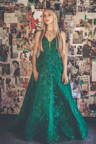 girl inside of a prom boutique taking pictures in a green prom dress