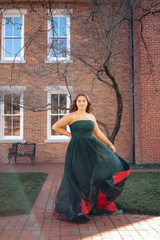 green ball gown prom dress with a building backdrop