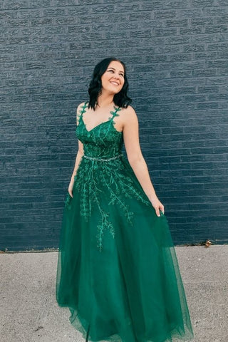 girl looking back in her green prom dress with thin straps and a-line bottom