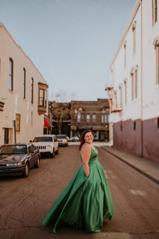 girl in the city wearing a green ballgown prom dress