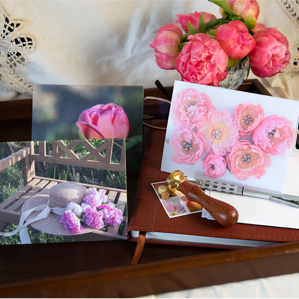 Peony greeting cards on a tray with writing materials and flowers.