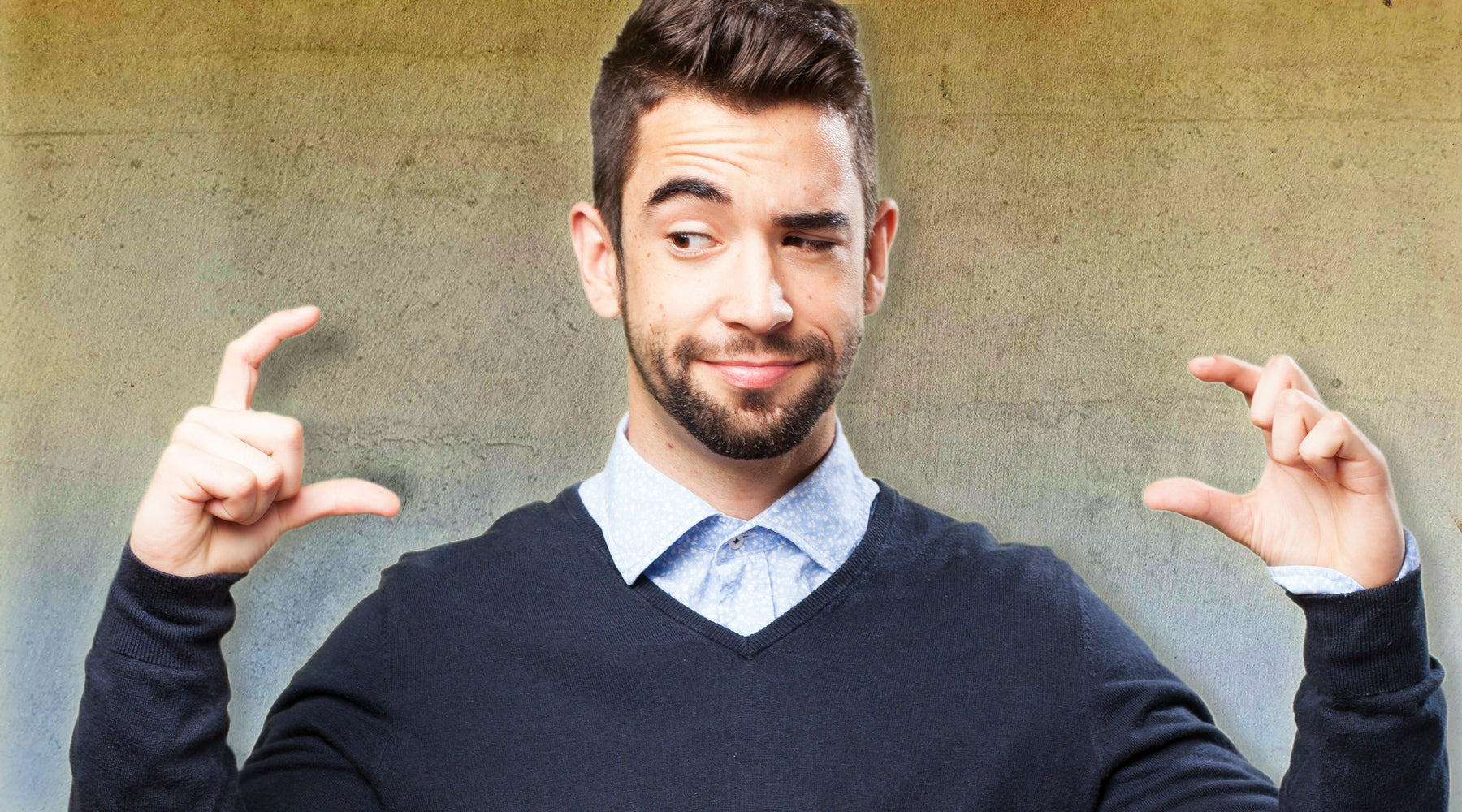 Man in collared shirt and sweater thinking about how Kegel exercises can make his penis bigger or stronger