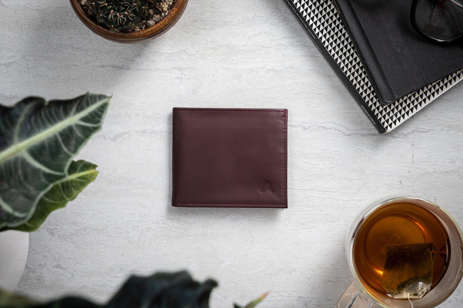 Allett Leather ID Wallet in Merlot sitting on an arranged table