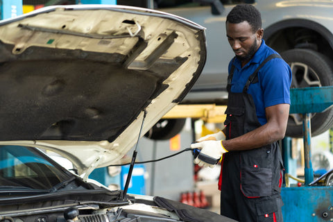 Professional car mechanic checking a car's engine control module with diagnostics software.