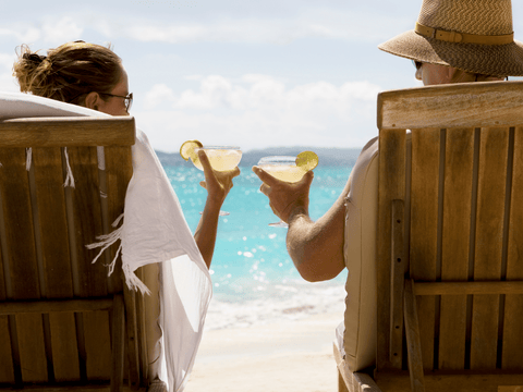 couple enjoying margaritas on the beach