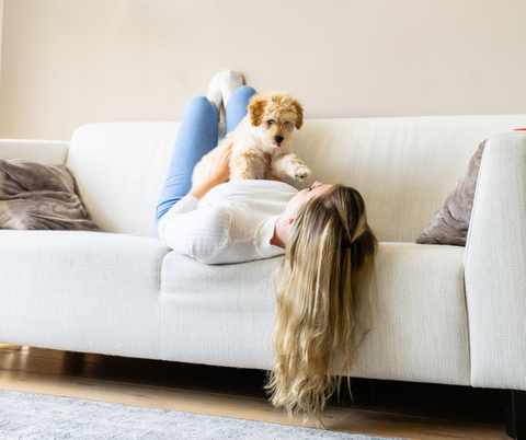 Das Yuki cares Partnerprogramm für passive Einnahmen - Frau mit Welpe auf Sofa