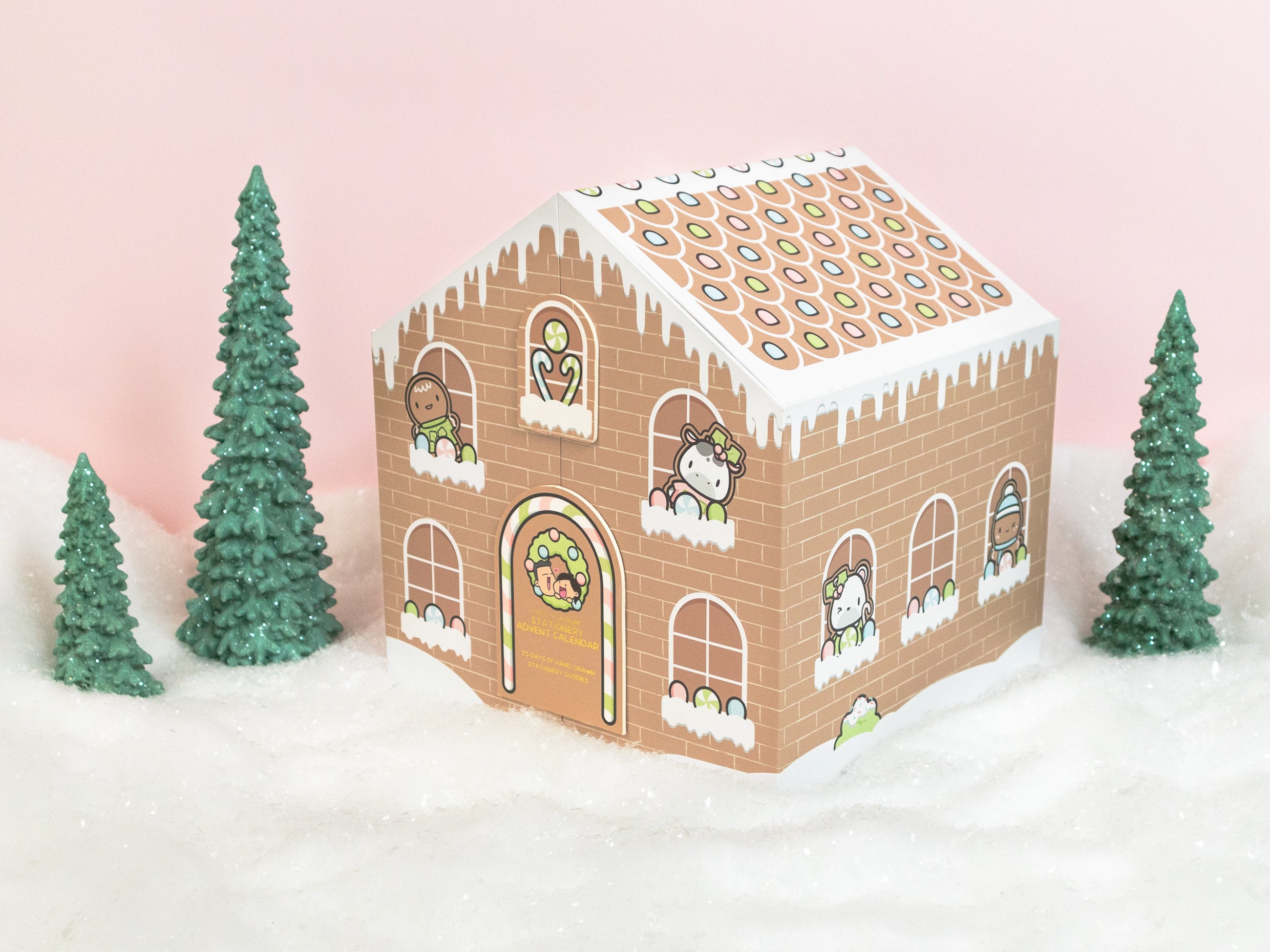 Gingerbread-themed advent calendar with cartoon characters, surrounded by snowy trees.