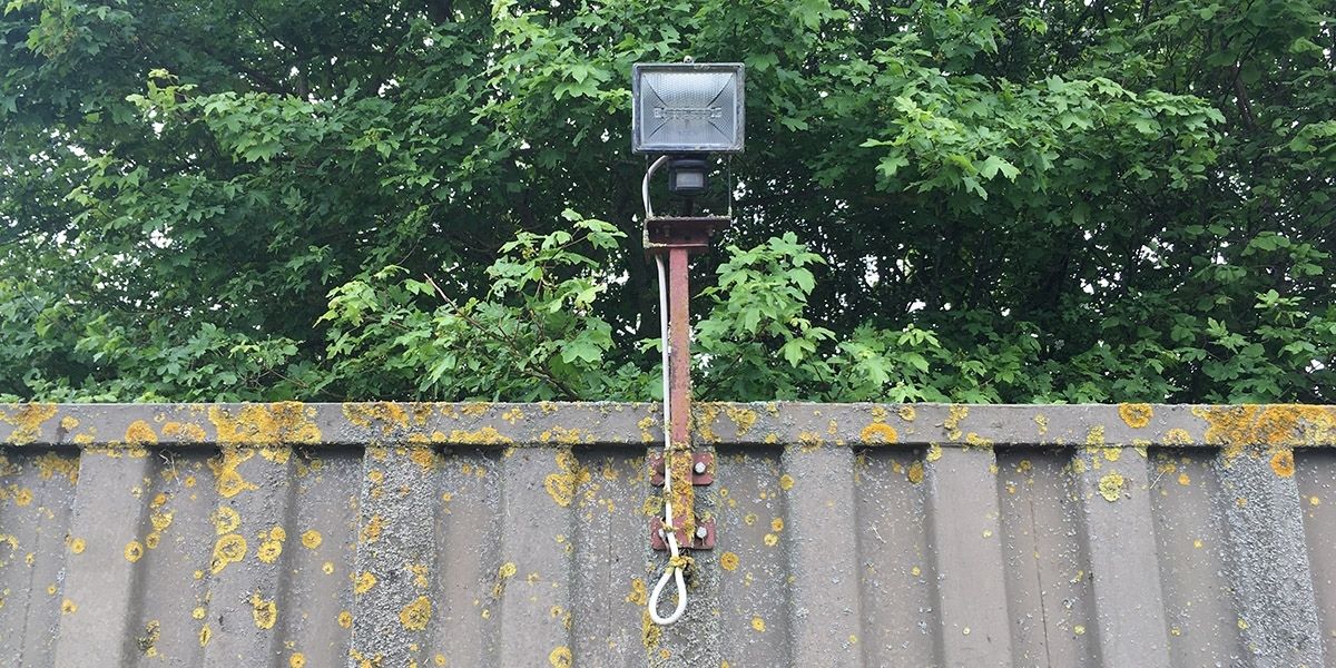 Floodlight bolted to a shipping container using a bracket