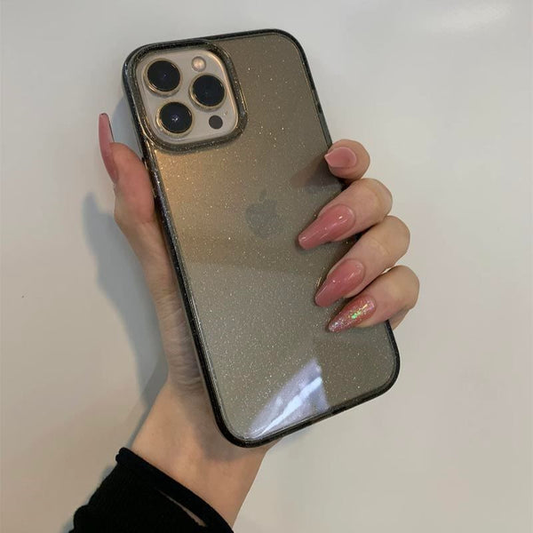 A hand holds a phone with a black sparkly case